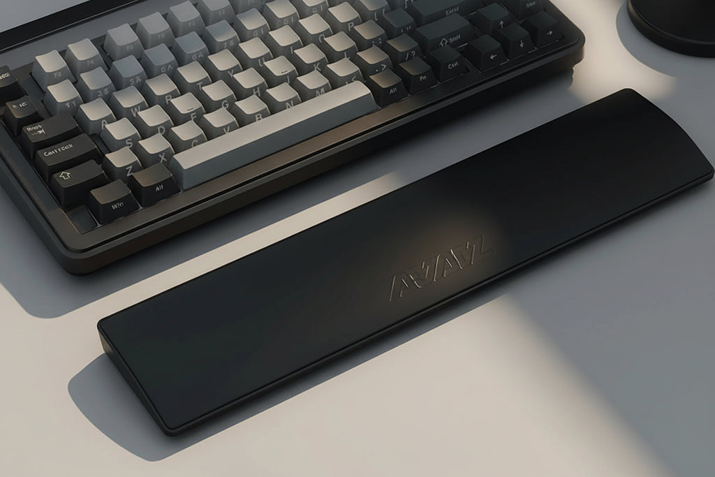 Black wrist rest pad with a computer keyboard on a desk, showing a close-up of hands typing.